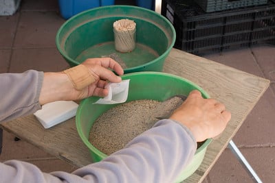Filling a tea bag with fertilizer